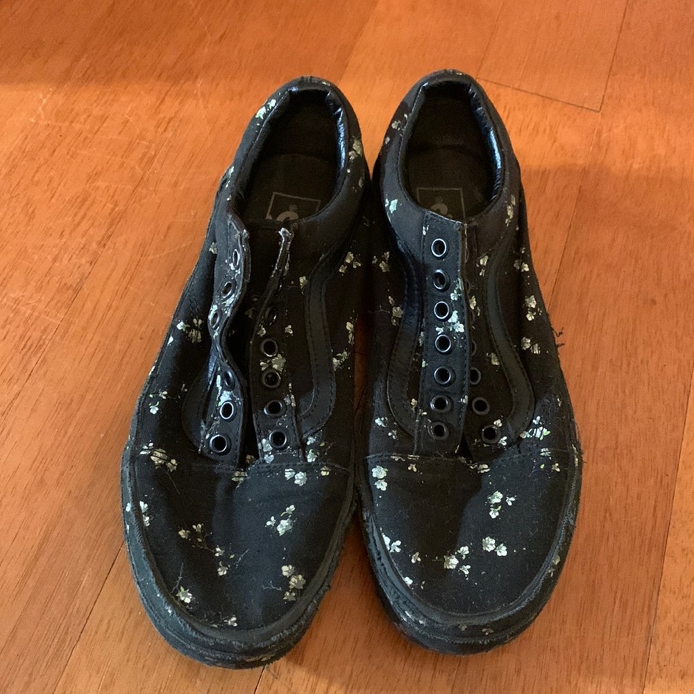 Black vans with flowers on them.